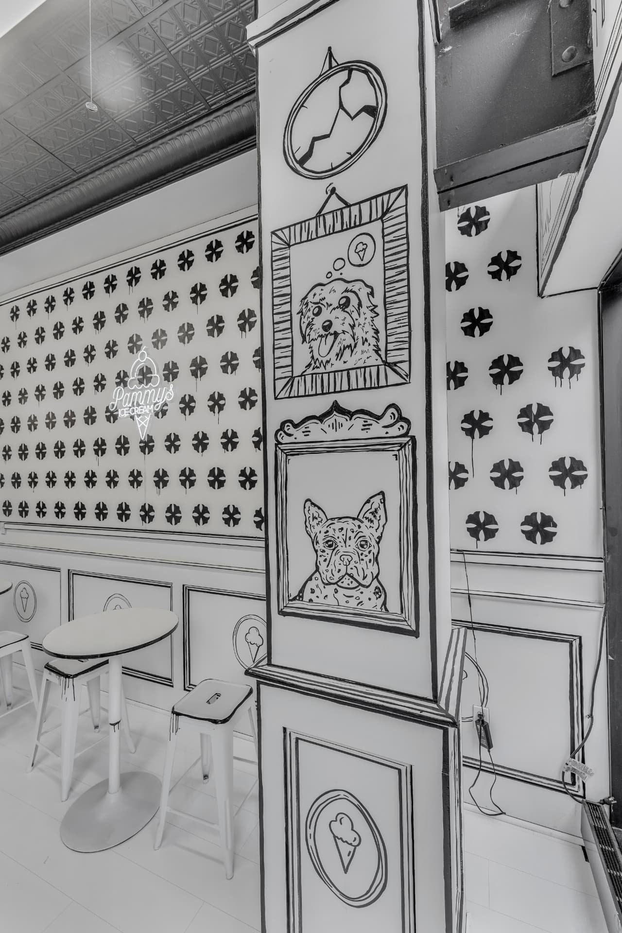 Hand-drawn dog portraits painted on a column in the seating area