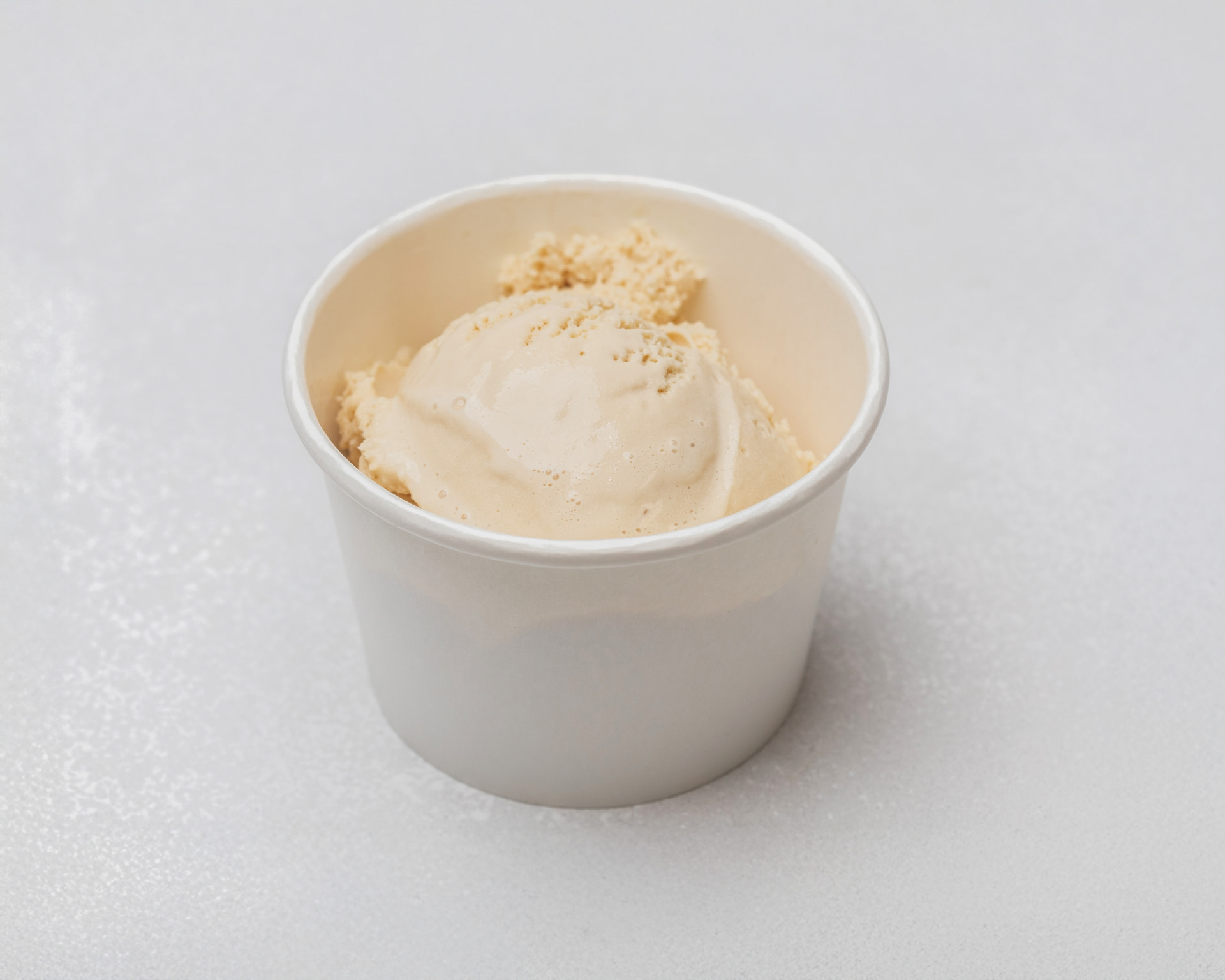 Pale espresso ice cream in a white cup