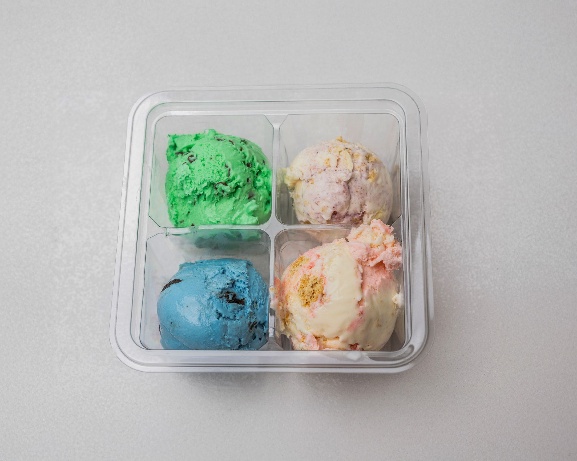 Four colorful scoops of Pammy's ice cream served in a clear flight tray