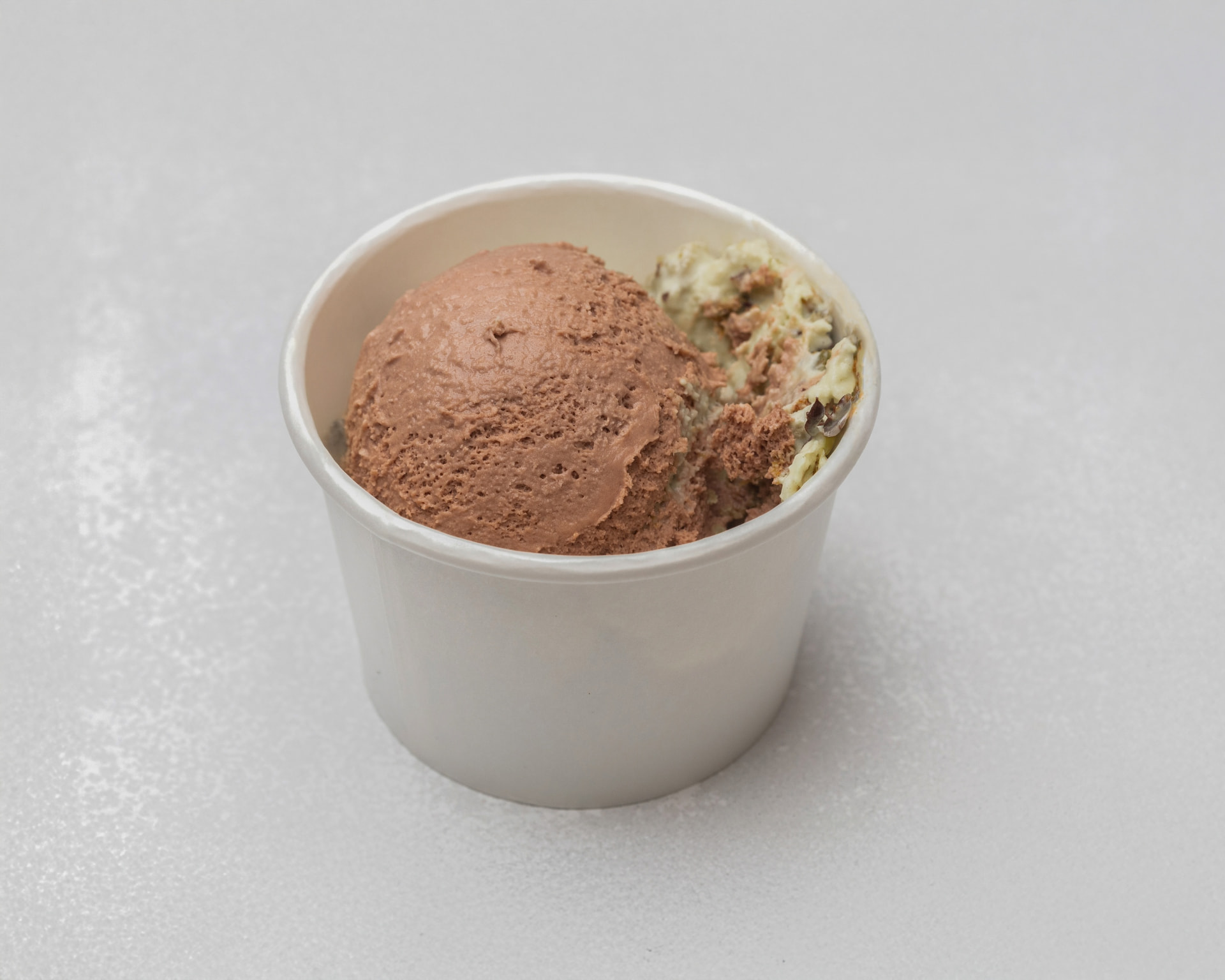 Chocolate and pistachio Dubai chocolate ice cream in a white cup