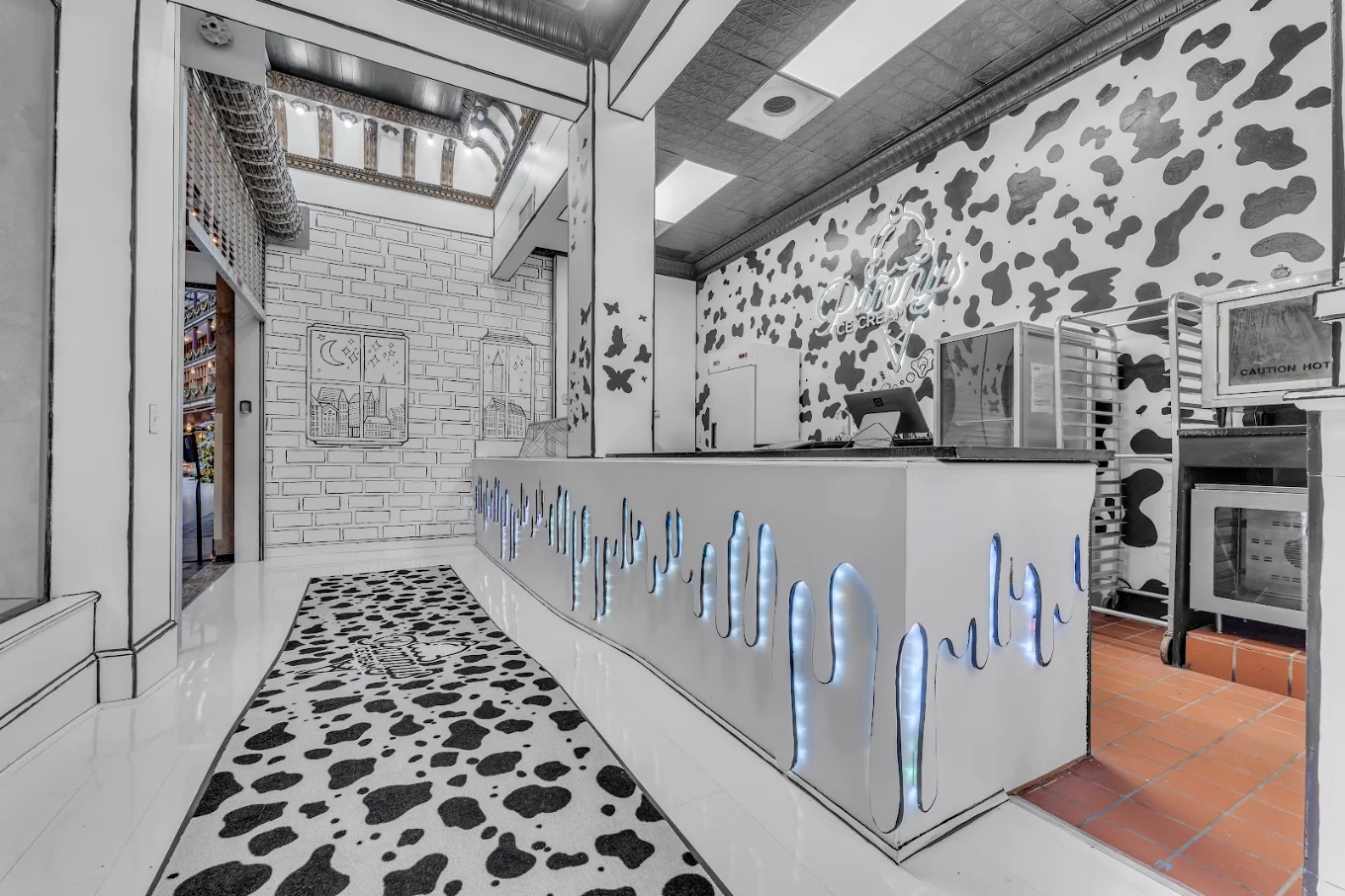 Pammy's Ice Cream counter with glowing drip details, cow-print walls and floor, and a neon logo inside the Cleveland Arcade