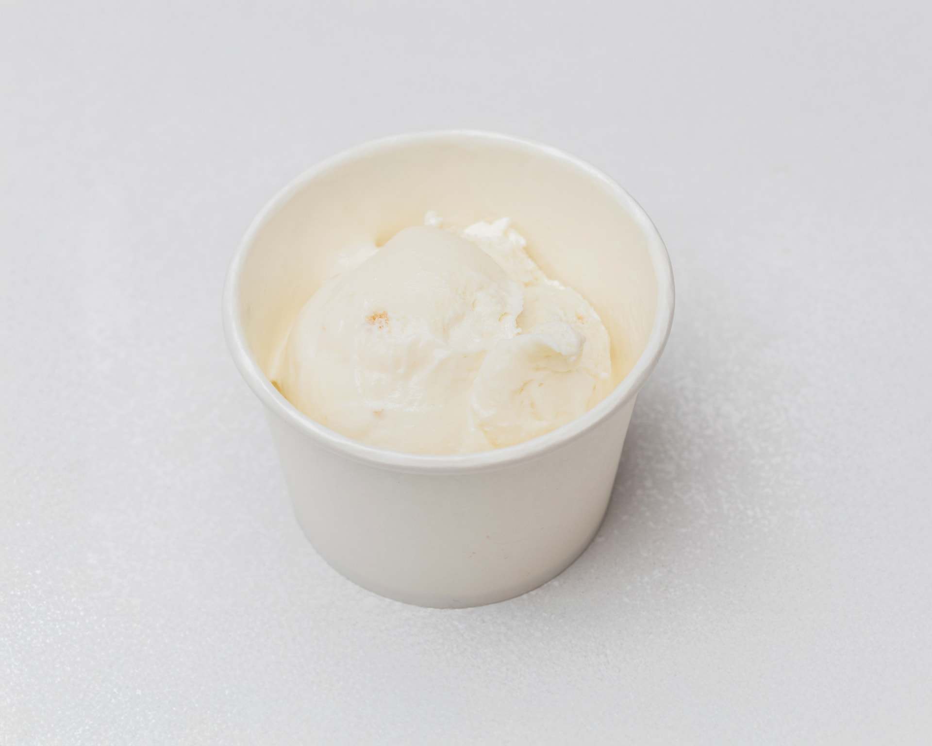 Cookie dough ice cream with dough chunks in a white cup